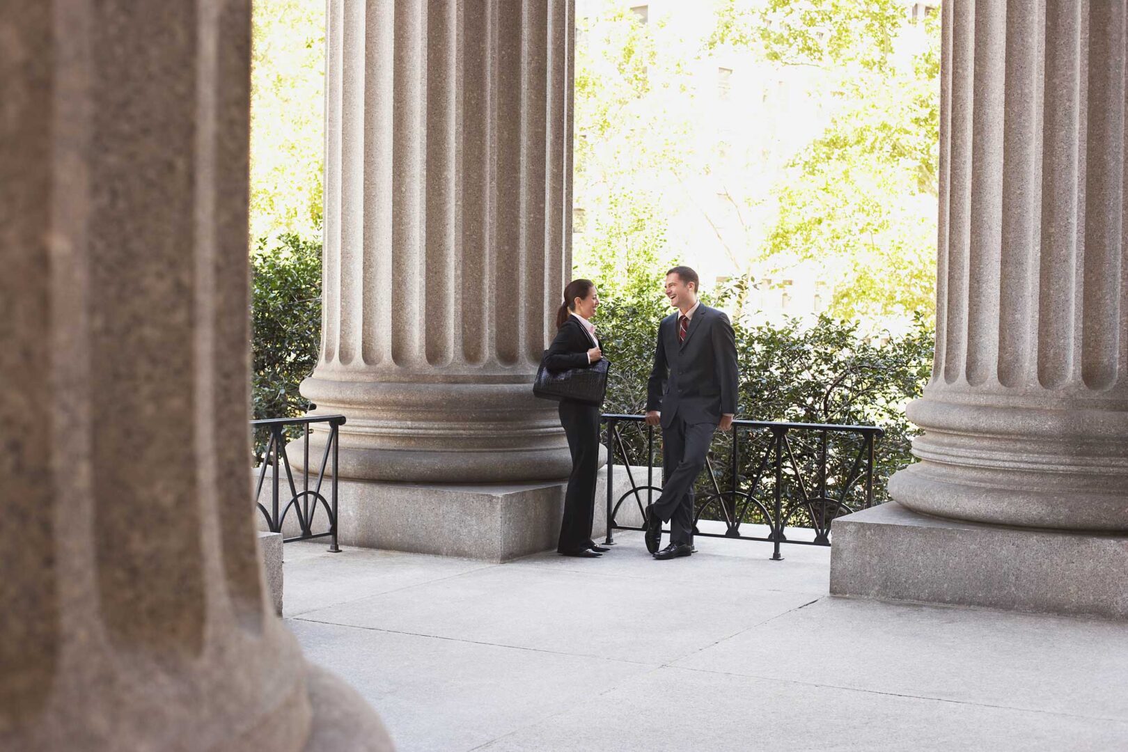 Two people standing next to a pillar on the ground