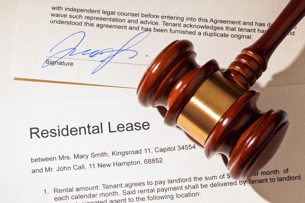 A wooden gavel sitting on top of papers.